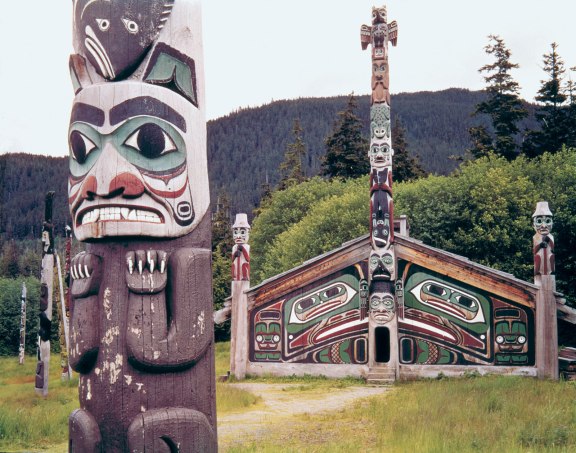 A Tlingit community house and totem poles are preserved in Totem Bight State Historical Park in Ketchikan, Alaska.